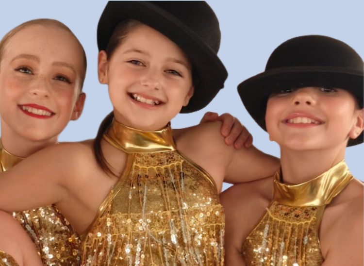 Three students dressed in gold dancing costumes and black top hat ready for a performance.