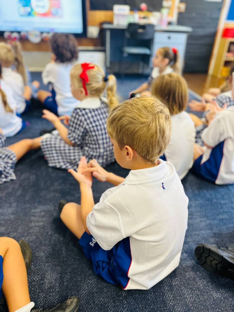 A kindergarten classroom with a student looking down counting.